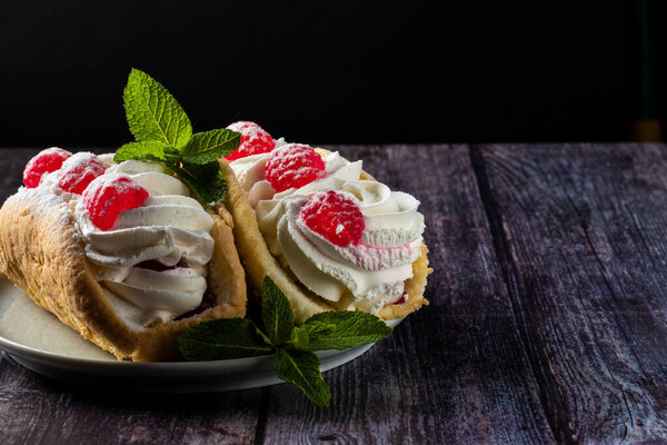 Airy raspberry cake in a plate on a wooden background