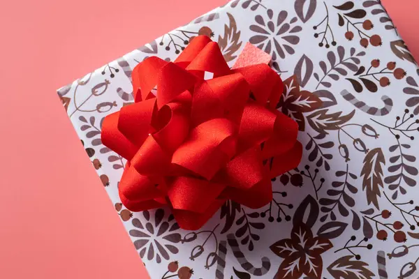 Κουτί δώρου με κόκκινο φιόγκο σε ροζ φόντο για τις διακοπές. Αντιγραφή χώρου — Φωτογραφία Αρχείου