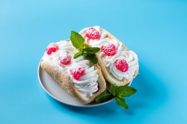 Mavi arka planda ahududu ve çikolata parçacıklı kek.