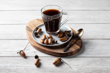 Meşe palamudu kahvesi kahve aromalı, bol renkli ve hoş aromalı bir toniktir. Beyaz ahşap arka planda