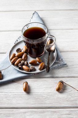 Bardaktaki meşe palamudu, kahve aromalı, bol renkli ve hoş aromalı tonik bir içecektir. Beyaz ahşap arka planda