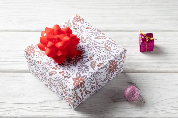 白色木制背景的节日礼品盒. 圣诞装饰品 — 图库照片
