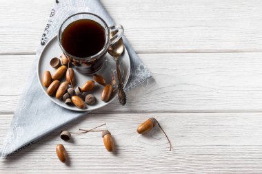 Bardaktaki meşe palamudundan yapılan sıcak kahve, kahve aromalı, bol renkli ve hoş aromalı bir toniktir. Beyaz ahşap arka planda