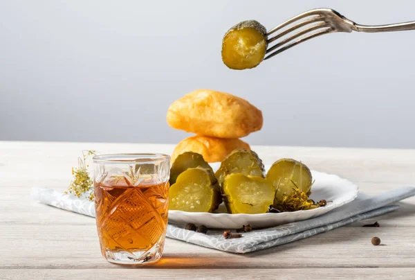 Op een houten tafel is een glas cognac, een hapje van een stukje donkere chocolade en een fles alcohol — Stockfoto