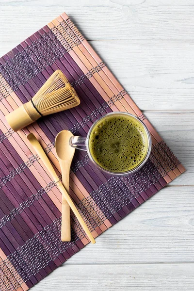 Bebida de chá verde matcha e acessórios em um fundo de madeira branco. Conceito de cerimônia de chá japonês . — Fotografia de Stock