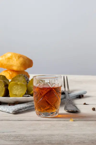 Op een houten tafel is een glas cognac, een hapje van een stukje donkere chocolade en een fles alcohol — Stockfoto