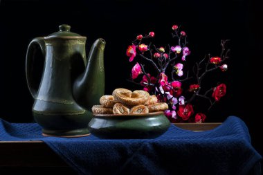 Hayat, arka planda çiçekler olan antika çömlekler.