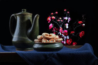 Hayat, arka planda çiçekler olan antika çömlekler.