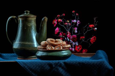 Hayat, arka planda çiçekler olan antika çömlekler.