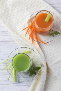 Fresh vegetables smoothie carrots, celery and greens with mint. On a light background