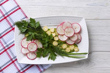Turp, mini mısır, salatalık ve bitkilerle vejetaryen salatası. Vitamin tabağı, fitness diyeti. Yatay yönelim, üst görünüm