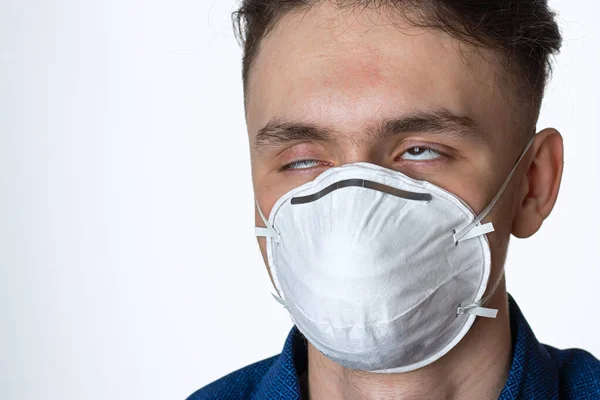 Портрет молодого человека в защитной маске от коронавируса, карантина, болезни на белом фоне — стоковое фото