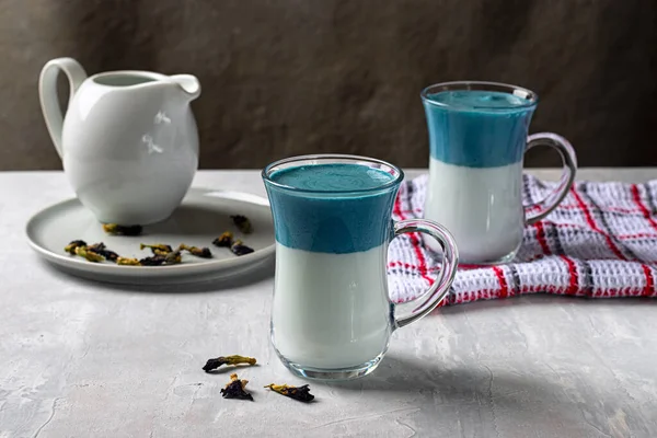 Latte Matcha Dalgona Niebieski groszek. Gorące świeże mleko z niebieskimi kwiatami grochu motyla lub clitoria ternatea latte w szklanym kubku. Orientacja pozioma — Zdjęcie stockowe