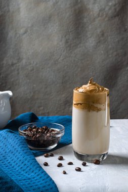 Dalgon kahvesi. Şekerli kremalı krema. Mavi arka planda bir fincan sütle. Dikey yönelim