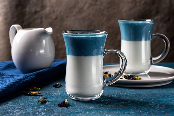 Blå matcha latte med mjölk. Fashionabla ärtor fjäril dricka Royaltyfria Stockbilder