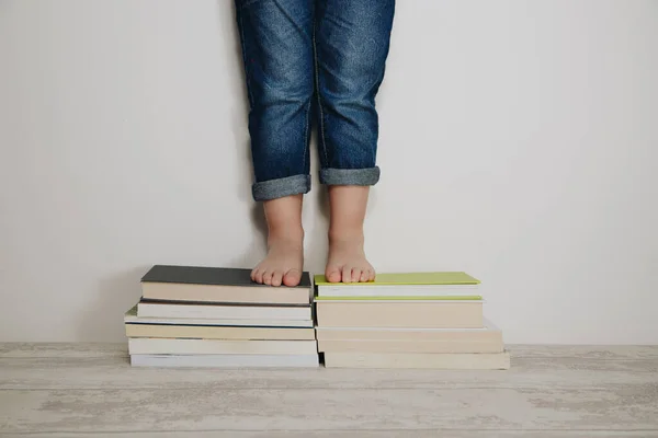 child standing on stacks of books. World book day concept