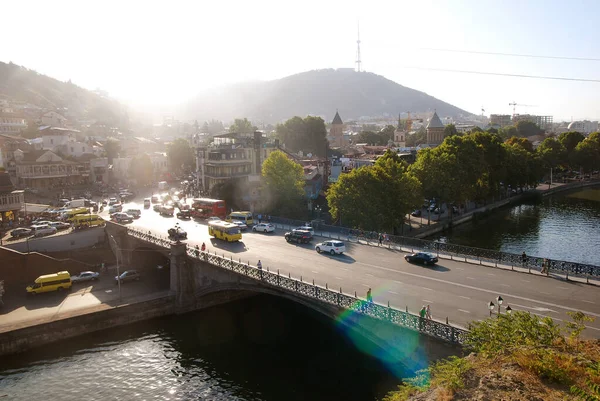 Gün batımında Tiflis 'teki Metekhi Köprüsü manzarası