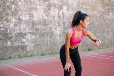 Sporcu kadın akıllı saat ile onun ilerlemesini kontrol ediyor.