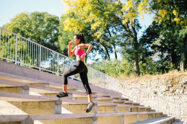 Antrenman sırasında merdivenleri çıkarken koşan kadın.