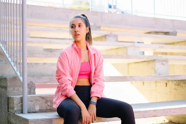 Woman taking a break from workout and sitting on stairs