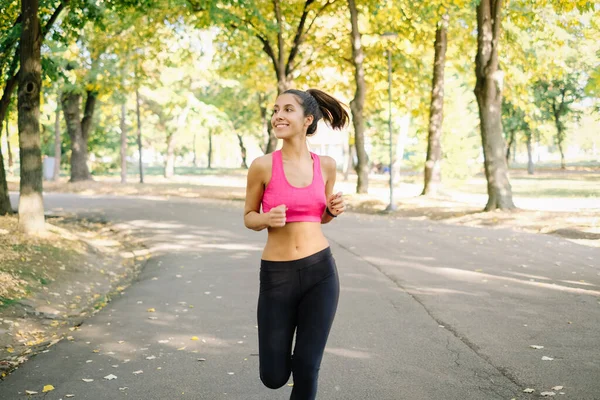 Femme sportive énergique et enthousiaste qui court dans le parc — Photo