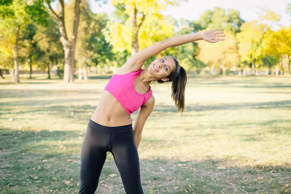 Woman with pink sports bra doing stretching