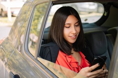 Serbest çalışan bir kız cep telefonuyla mesaj atıyor.