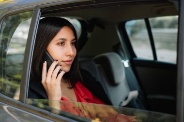 Çekici avukat arabada telefonla konuşuyor.