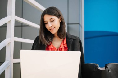 Ofis dışında dizüstü bilgisayarda çalışan kadın yönetici.