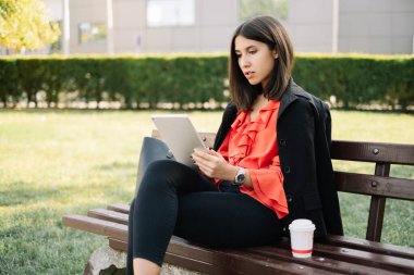 Gümüş tabletine bakan ciddi bir kadın.