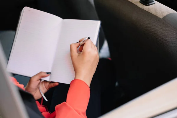Woman handwriting on backseat of a car