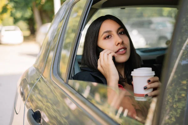 Female manager using mobile while sitting in car