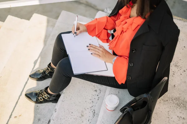 Cropped image of woman handwriting in notebook