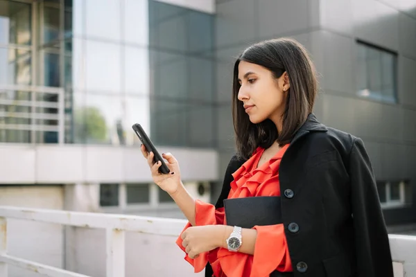 GIrl dressed with elegant clothes looking at her cellphone