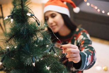 Noel topunu yeşil ağaca koyuyor