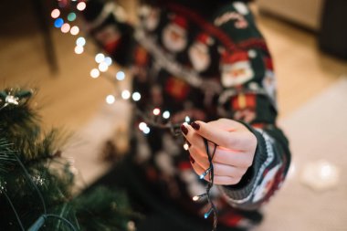 Renkli ağaç ışıkları tutan bir kadının kesilmiş fotoğrafı.