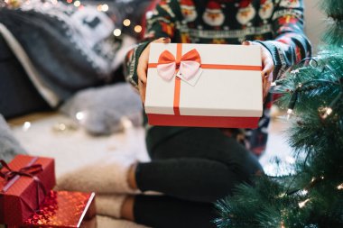 Kadınların el ele tutuşup hediye kutusunu tuttukları yakın çekim.