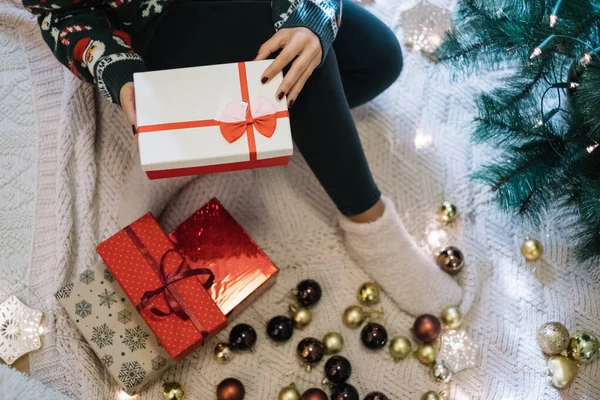 Immagine ritagliata di donna seduta su una coperta con scatole regalo — Foto Stock