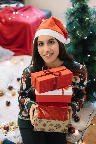 Femme assise sur le sol et tenant des cadeaux de Noël — Photo
