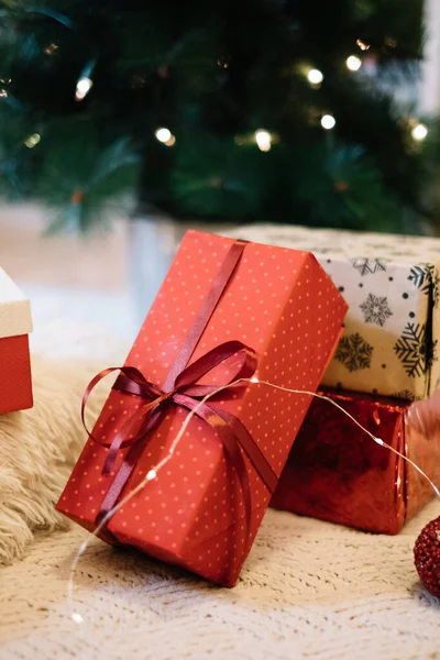 Presente imballato con carta rossa su punti sotto l'albero — Foto Stock