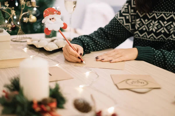 Noel Baba kalemle Noel kartı yazan kadın.