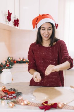 Gülümseyen kadın hamur için tarçın somurtuyor