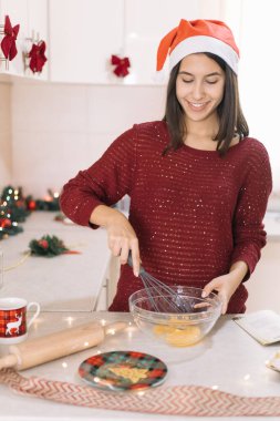 Gülümseyen kız yumurtayı kışkırtıcıyla karıştırıyor.