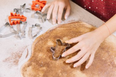Kurabiye kesiciyle hamuru kesen kadının yakın çekimi.
