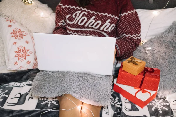 Fille avec ordinateur portable blanc au lit avec des lumières de Noël — Photo