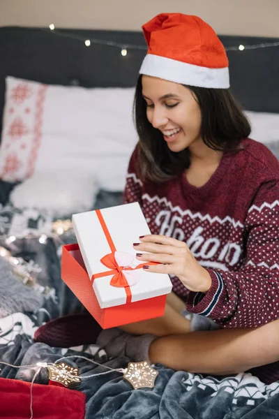 Dívka s santa hat otevírání vánoční dárek — Stock fotografie