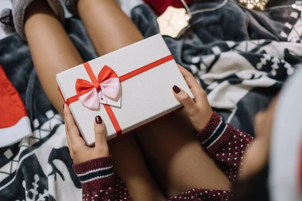 Cropped woman laying in bed with present