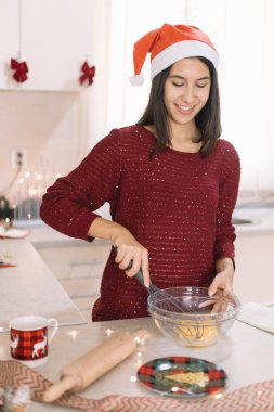 Mutfakta Noel için dekore edilmiş yumurta karıştıran bir kız.