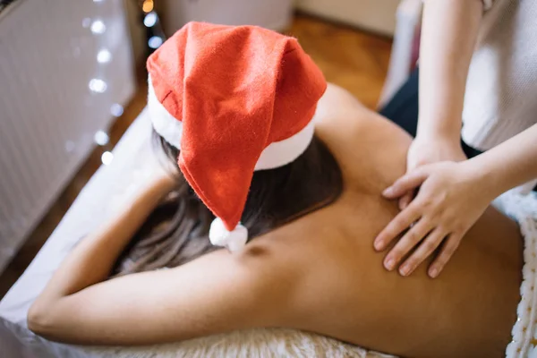Chica acostada en la cama de masaje en el salón de spa recibiendo masaje —  Fotos de Stock