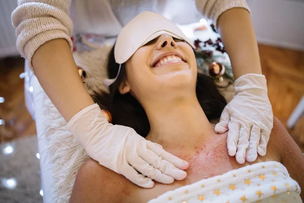 Kadınlar gülümserken, spa terapisti göğsünü ovalıyor.
